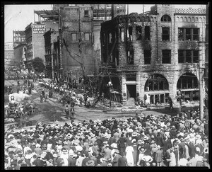 Exterior view of the Los Angeles Times buliding as seen from the corner of Broadway and First Street, showing the damage from a bomb blast and fire as well as a crowd of onlookers, October, 1910