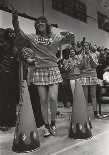 Cheerleaders cheering at basketball game, circa 1973