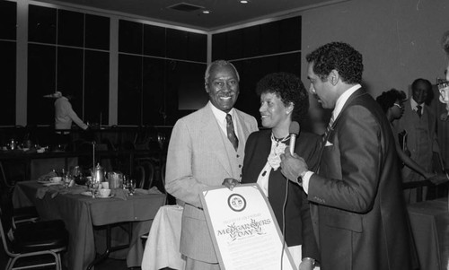 Myrlie Evers receiving a "Medgar Evers Day" proclamation from Nate Holden, Los Angeles, 1983