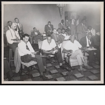 C.L. Dellums with group of men reading in chairs