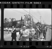 Members of St. Peter's Church carrying Madonna of the Stars in procession down street in Los Angeles, Calif., 1976