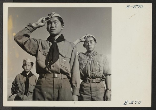 Boy Scouts conducting morning flag raising ceremony at the Heart Mountain Relocation Center, where persons of Japanese ancestry, evacuated from west coast defense areas, now reside. Photographer: Coffey, Pat Heart Mountain, Wyoming