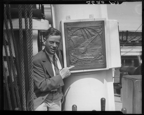 Man pointing to plaque on mast of S.S. Constitution, San Diego Harbor, San Diego, 1934