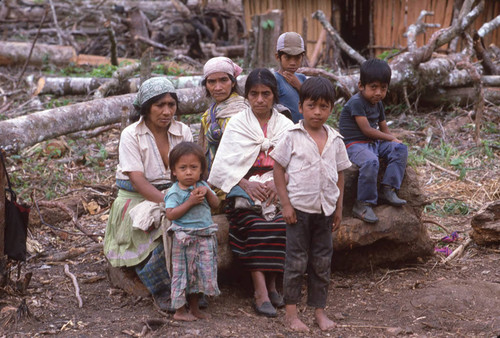 Guatemalan refugees sit on a tree trunk, Chajul, ca. 1983