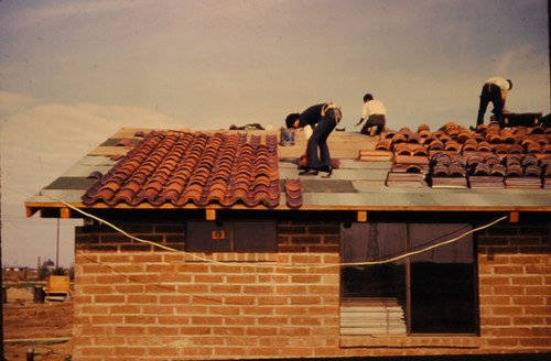 Volunteer placing roof tiles at Agbayani Village