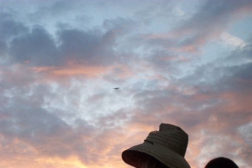 Airplane flies above hat
