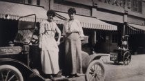 Ladies posing on the running board on a car in front of the Granger & De Hart Garage