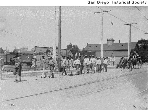 Mexican refugees walking along a street under the guard of US Soldiers