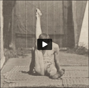 Man in pelvis cloth performing contortions on the ground