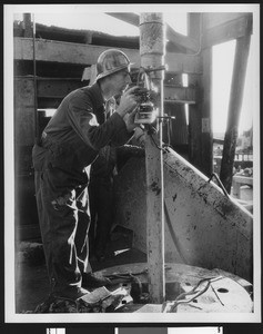 Man working in a Shell Oil Company refinery, ca.1940