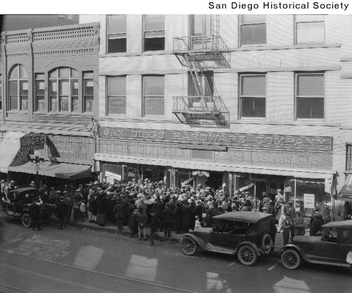 Large group of people gathered for a sale outside the San Diego Hardware Company on Fifth Avenue