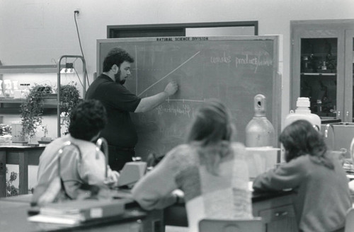 Photograph of Dr. Gary Tallman , Biology Professor, at the chalk board