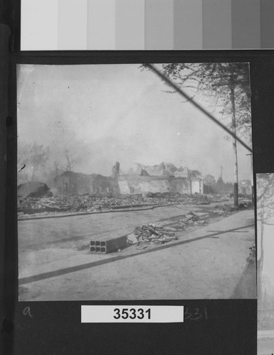 [Ruins and rubble along unidentified street.]
