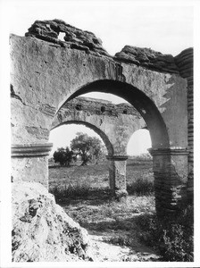 Pepper tree seen through the ruined arches of Mission San Luis Rey de Francia, 1900