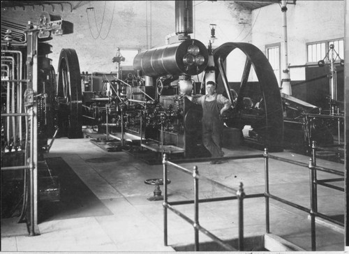 Plant Engineer Milton Nicholson stands by the Corliss engine at the Oxnard Steam Plant, about 1910