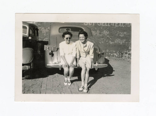 Young women sitting on a car