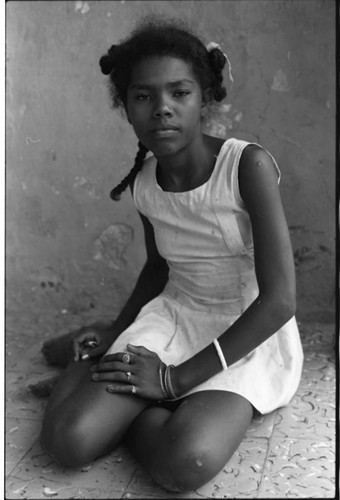 Girl sits outdoor on the floor, San Basilio de Palenque, 1975