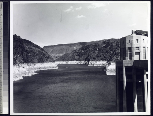 Lake Mead from dam crest with Lake Mead at low capacity showing high water mark on sides of canyon walls and one of the intake towers on the right