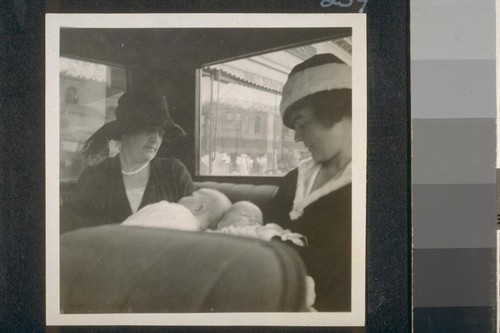 [Two women and babies in car]