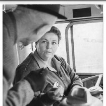 Terry Hixon (woman bus driver) at the wheel of the No. 8 bus (with male passenger), which went past the Bee building over to the Med Center (then the county hospital)