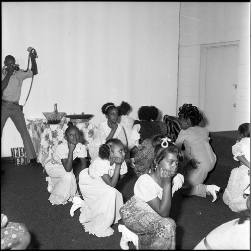 Photographer capturing Mrs. Cunningham's charm school students in a pose, Los Angeles, 1972