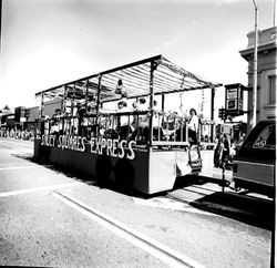 1978 Apple Blossom Parade Sebastopol with the Saucy Squares Express float being pulled by a car, at the corner of Main Street and Bodega Avenue