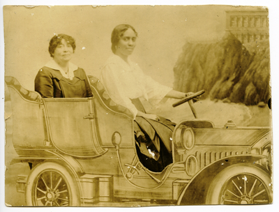 Portrait of two women sitting in painted automobile backdrop