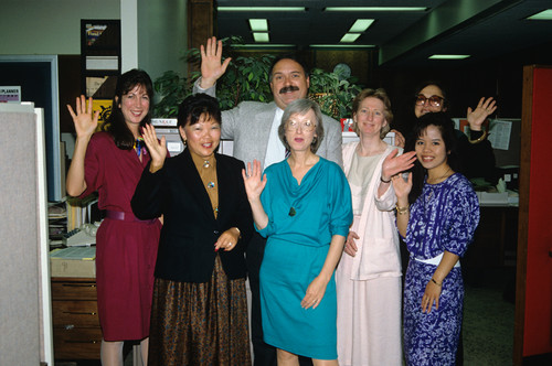 Seven people waving to the camera