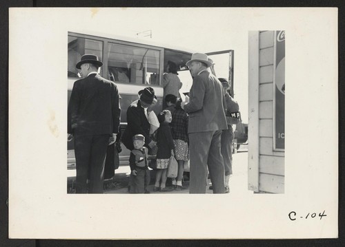 Byron, Calif.--The bus which will take this farm family of Japanese ancestry to the Assembly Center is almost ready to leave. Note identification tag on small boy. Photographer: Lange, Dorothea Byron, California