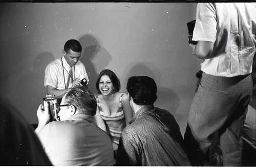 Photographers surrounding model in a studio