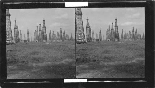 Spindle Top Oil Field, near Beaumont, Texas, the first oil field to be struck in Texas. You are standing on the old foundation of the first well brought in this field & it is still producing. The first 14 wells before your eyes are producing oil each from a different strata, thus making this the outstanding oil field in the world. These many strata account for the proximity of the derricks. #36