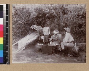 Missionary and wife eating breakfast on travels, Delena, Papua New Guinea, ca. 1905-1915