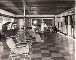 Nurse helping patients in wheel chairs in the solarium at the old Palm Drive Hospital
