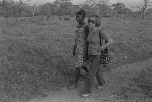 Nina S. de Friedemann walking with a women on a trail, San Basilio de Palenque, ca. 1978