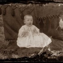 View of a baby with a tapestry behind