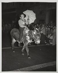 Woman on a donkey with a parasol--Admission Day Parade