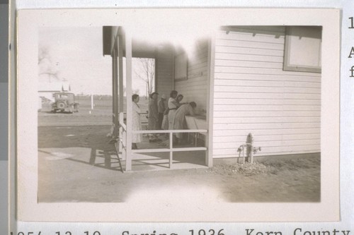 Spring, 1936, Kern County. Arvin Migratory Labor Camp - Laundry trays in use under the shade in the end of the sanitary unit