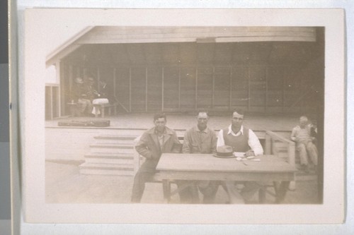 Spring, 1936, Kern County. Arvin Migratory Labor Camp - The Camp Committee - Easton, the chairman sitting in the center. Recreation platform, stage, in the background