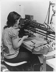 Unidentified woman operating a wire coiling machine, 1970s