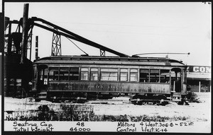 Side view of Pacific Electric railway car near industrial building, ca.1912
