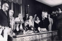 Patricia Whiting and other legislators look on as Governor McCall signs a bill