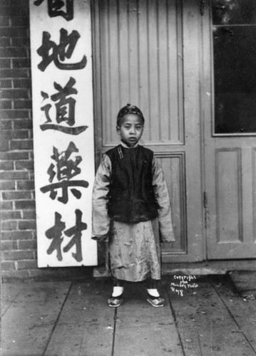 Youngster standing next to banner