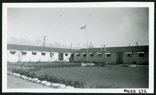 Photograph of the Manzanar administrative buildings with a flag flying