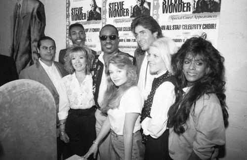 Stevie Wonder posing with Celebrity Choir members at a press conference, Los Angeles, 1989