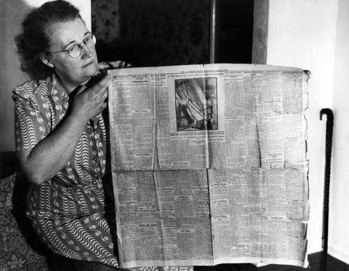 Mrs. Middleton shows off antique newspaper