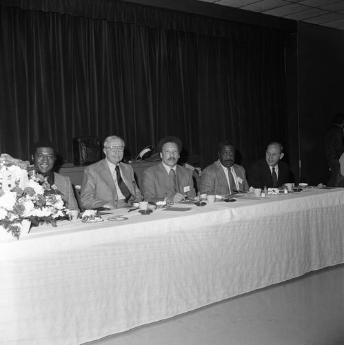 Black Business Association luncheon participants posing while at a table, Los Angeles, 1973