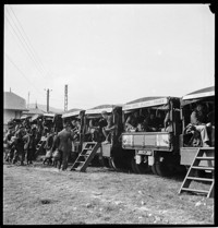 Fussen [American soldiers (Airborne?) in backs of a row of trucks with USRRA signs]