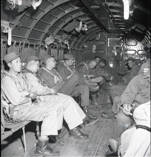 Troops strapped into a transport plane