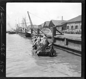 Family moving all their possessions in a river skiff in China, ca.1900
