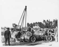 Tow truck separating a pile of wrecked racing cars